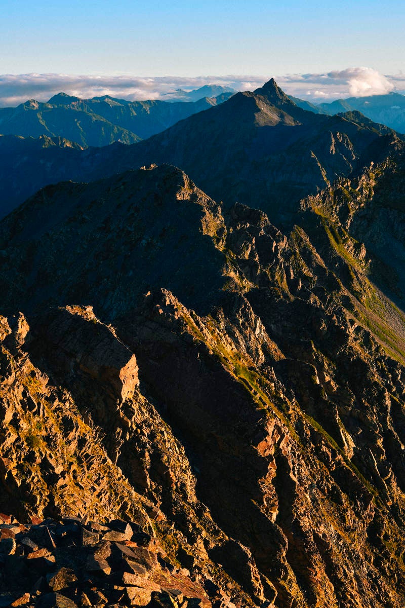 朝日に照らされて黄金色に輝く奥穂高岳の険しい稜線と山脈