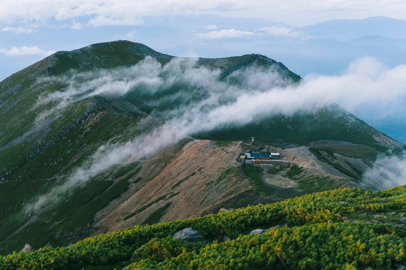 「流れる雲に包まれる五ノ池小屋と継子岳」の写真