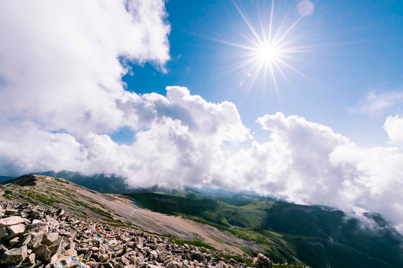 陽光照り付ける薬師岳山頂の写真