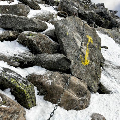 積雪と蓼科山山頂へ向かう矢印と鎖の写真