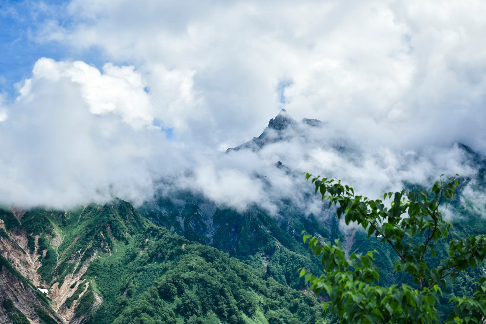 「ガスに包まれた槍ヶ岳山頂を眺める（鷲羽岳） | フリー素材のぱくたそ」の写真