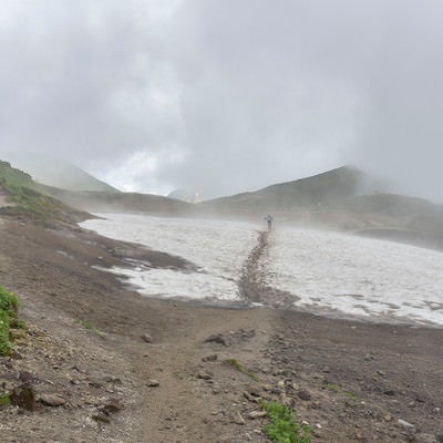 ガスの稜線を歩く登山者（弓折乗越）の写真