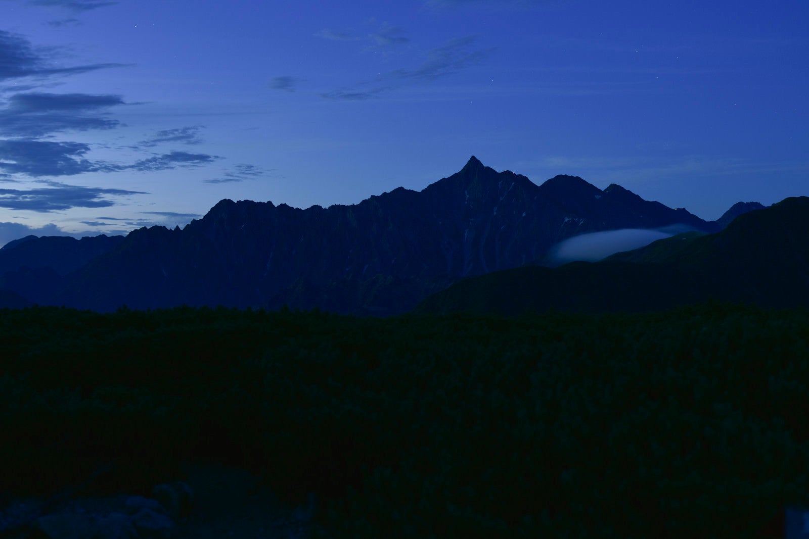 「夜明けにシルエットが浮かび上がる槍ヶ岳（鷲羽岳）」の写真