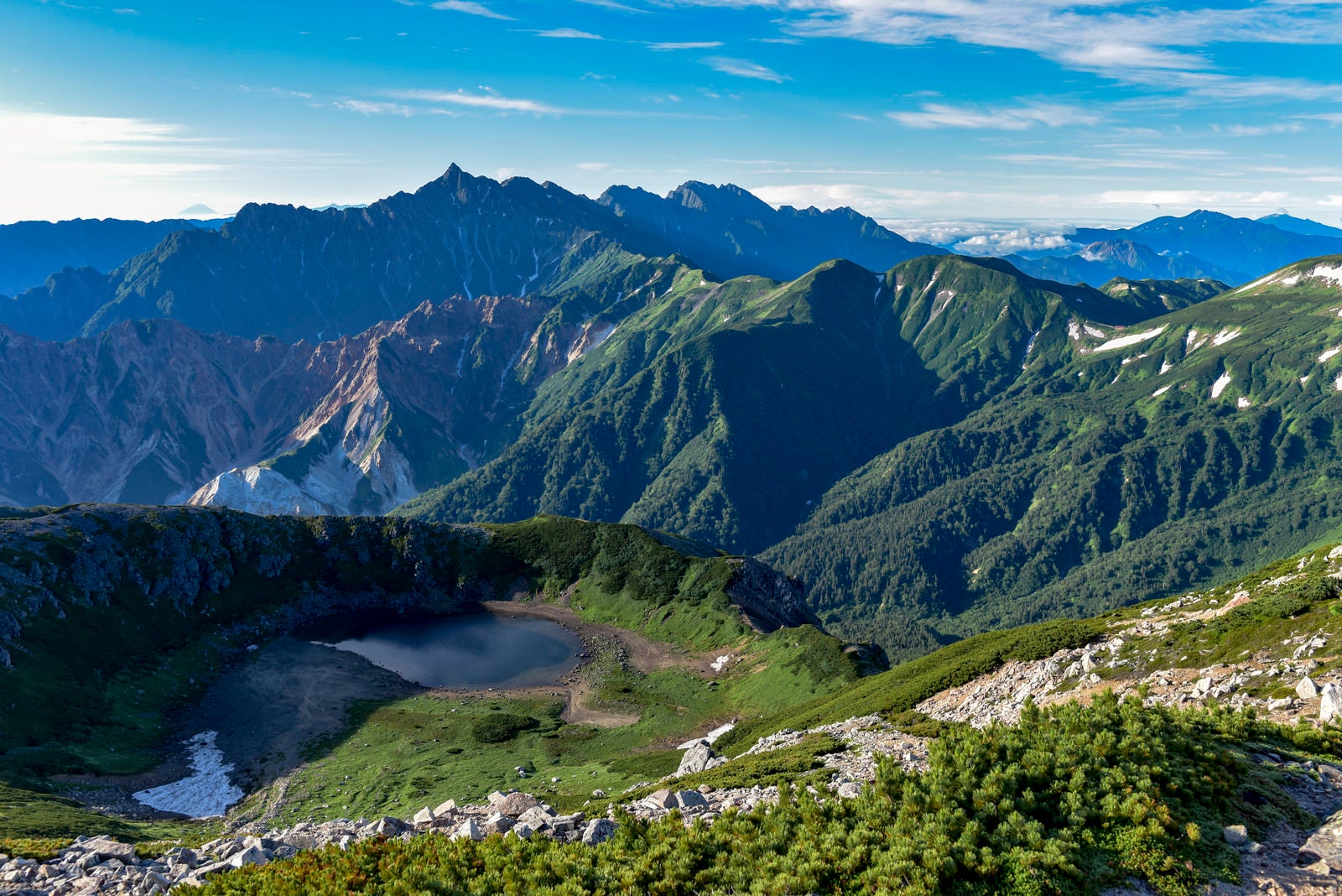 「快晴の鷲羽岳山頂から見る鷲羽池と槍ヶ岳方面の景色」の写真