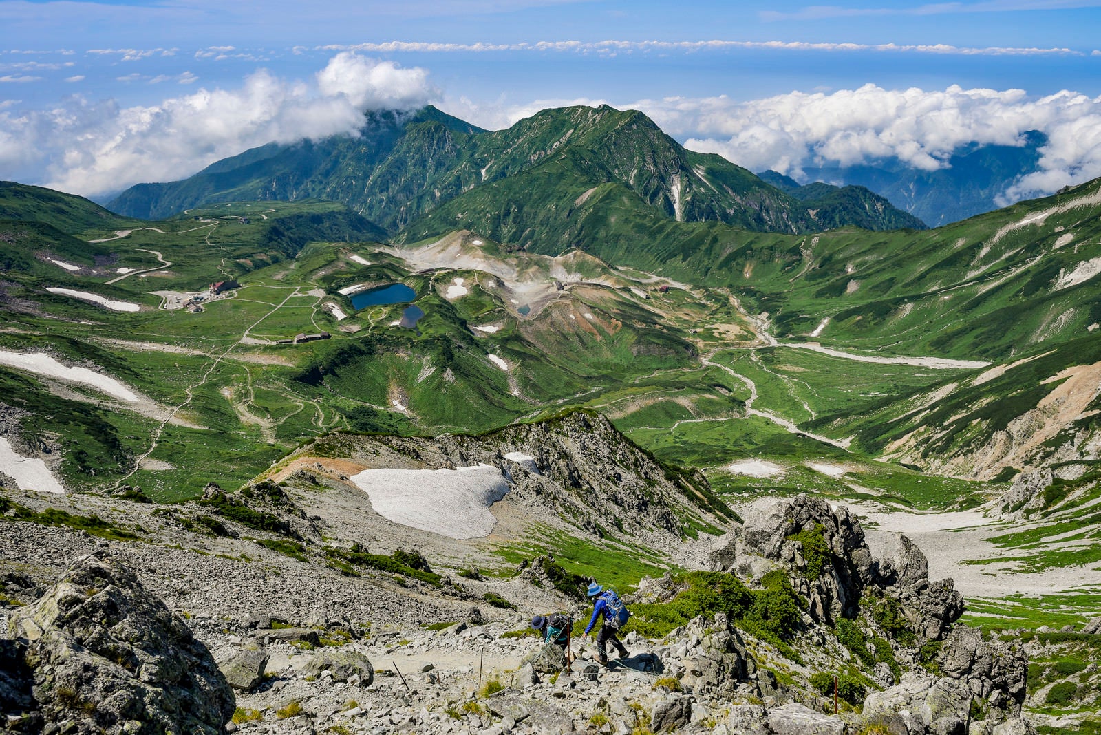 「立山室堂と雄山へと向かって歩く登山者」の写真