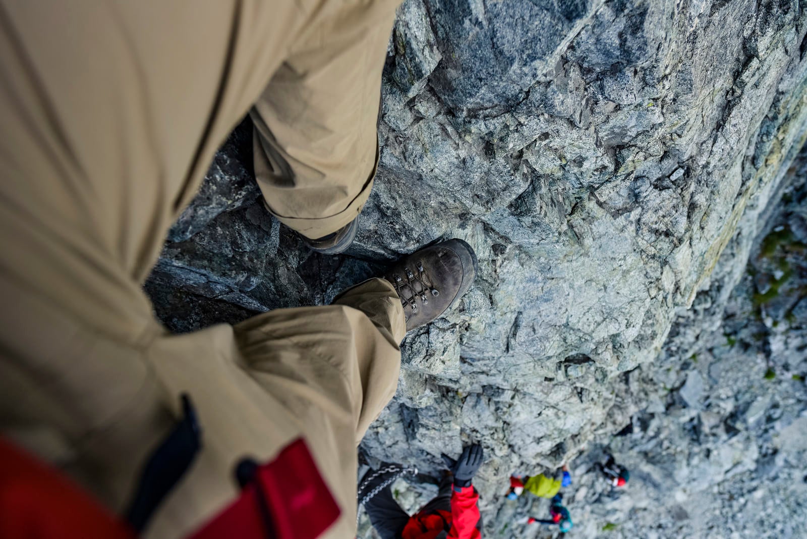「剱岳の小さな足場に足をのせる登山者の目線」の写真
