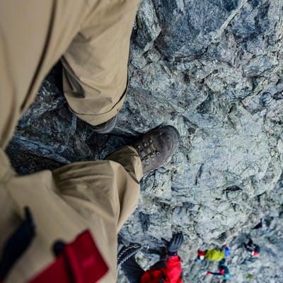 剱岳の小さな足場に足をのせる登山者の目線の写真