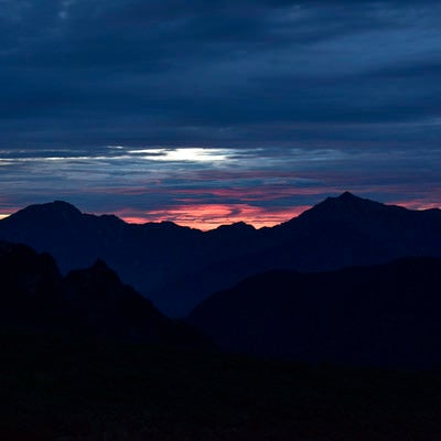 剱岳の麓から見上げる北アルプスの夜明けの写真