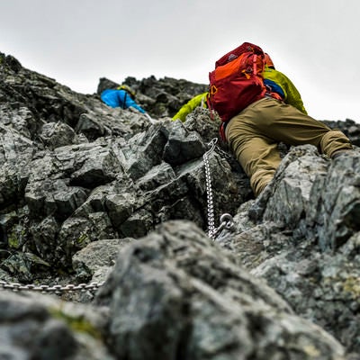 岩の剱岳を登って行く登山者の写真