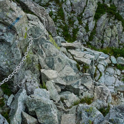 岩肌に鎖が付けられた剱岳の登山道の写真