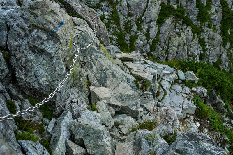 岩肌に鎖が付けられた剱岳の登山道の写真