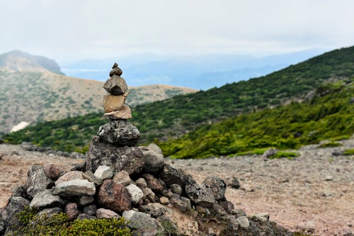 安達太良山の稜線に積み上げられたケルンの写真