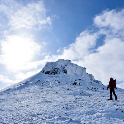 安達太良山山頂を眺める赤い登山者の写真
