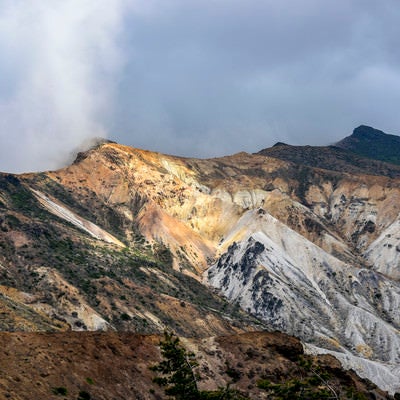 雲に包まれる安達太良山爆裂火口の斜面の写真