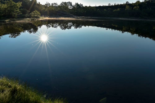 弓池の湖面に反射する太陽（草津白根山）の写真
