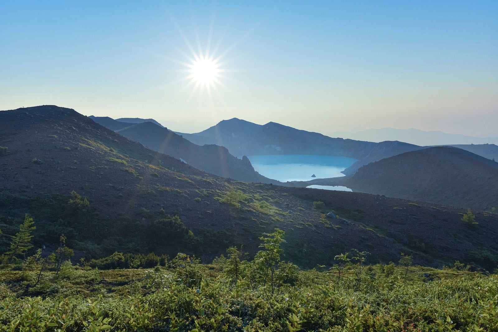 「朝焼けに輝く草津白根山湯釜」の写真