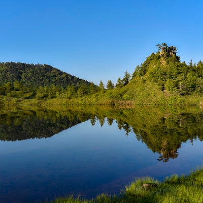 湖面に反射する弓池の景色（草津白根山）の写真
