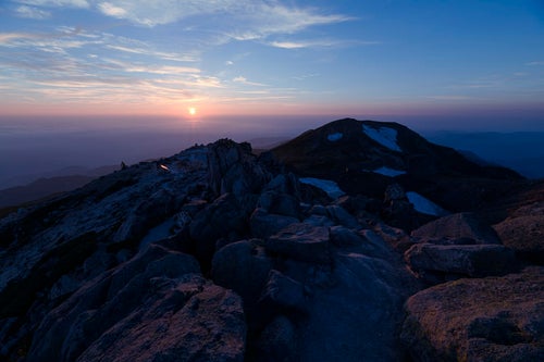 大汝峰の向こう側に沈む往く太陽（白山）の写真