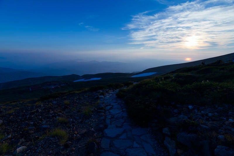 日本海に沈む夕日を眺めて歩く白山登山道の写真