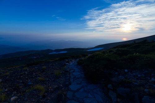 日本海に沈む夕日を眺めて歩く白山登山道の写真