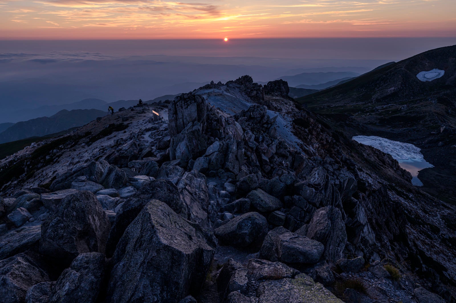 「沈みゆく太陽と白山山頂の岩」の写真