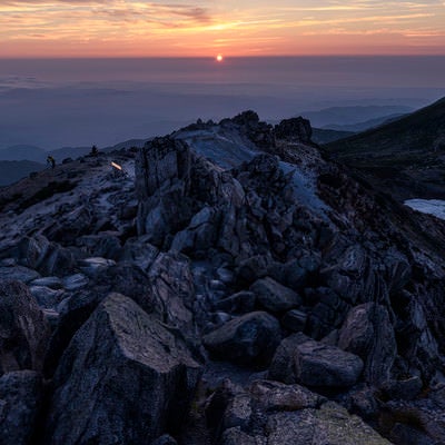 沈みゆく太陽と白山山頂の岩の写真