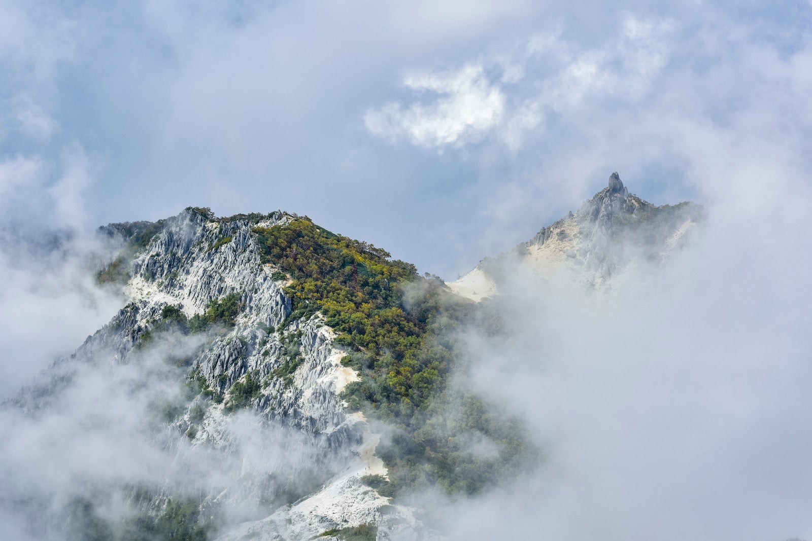 「雲の向こうに顔を出す鳳凰山オベリスク（鳳凰三山）」の写真
