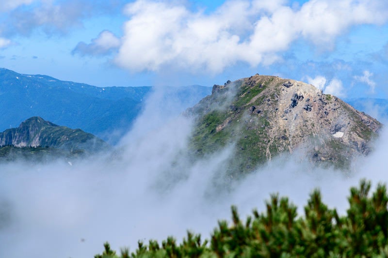 新潟焼山と雨飾山の山頂（火打山）の写真