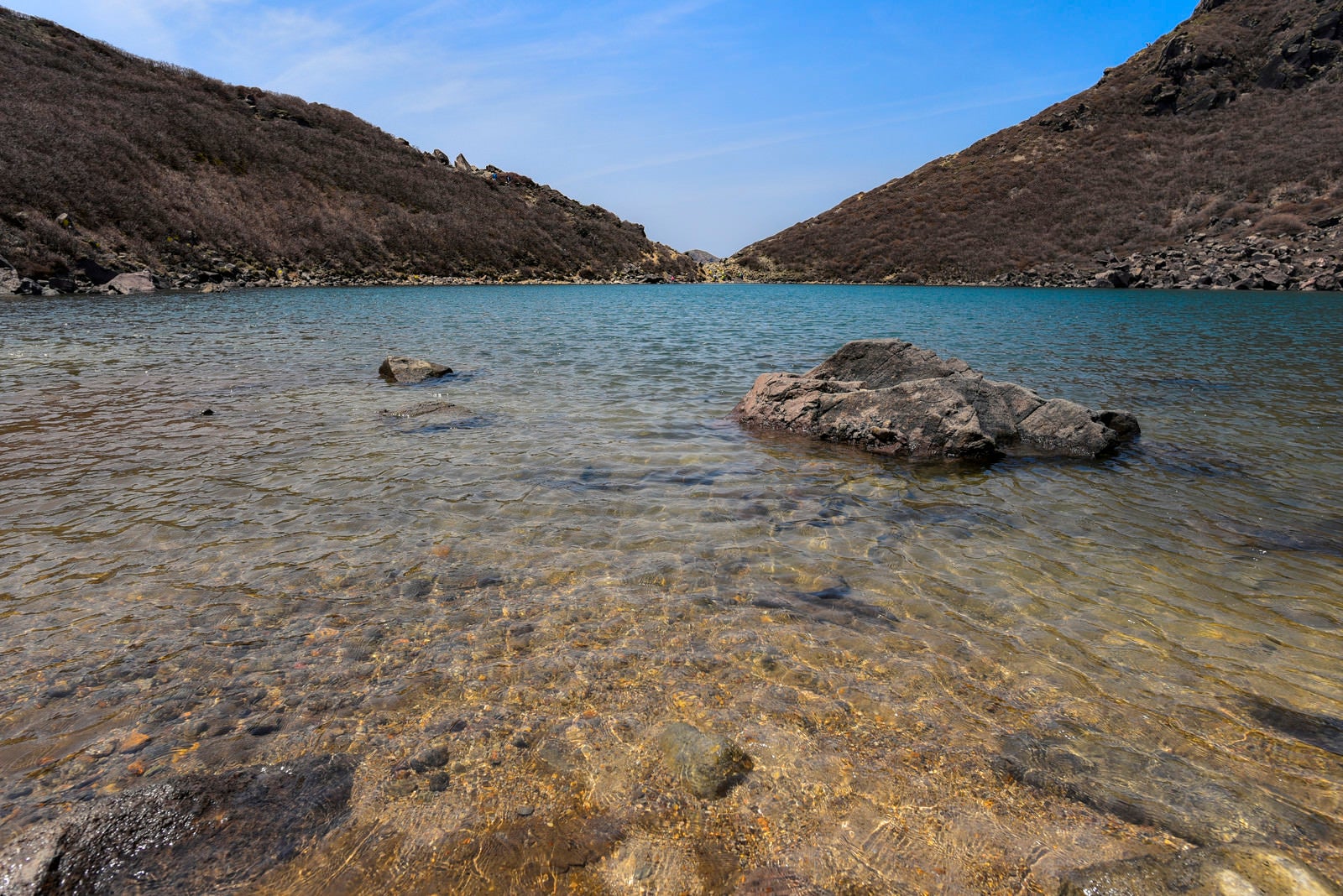 「久住山御池に積み重なった岩と真っ青な水（大分県）」の写真