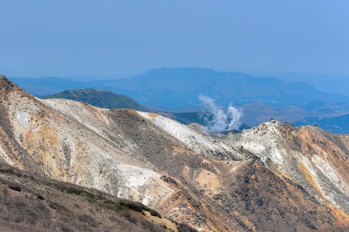 煙を上げる久住山の稜線（大分県）の写真