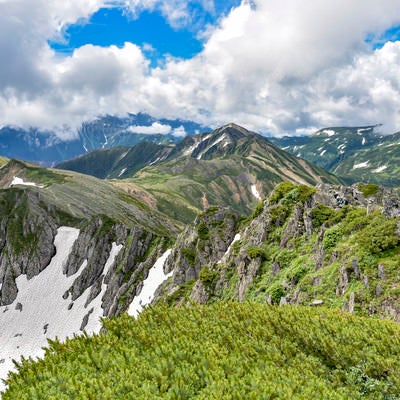 青空と白い雲が広がる水晶岳稜線からの景色の写真
