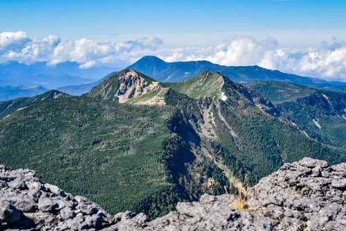 横岳の奥に見える蓼科山方面の姿（赤岳）の写真