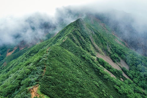 赤岳方面から見る雲に包まれた阿弥陀岳側登山道の写真