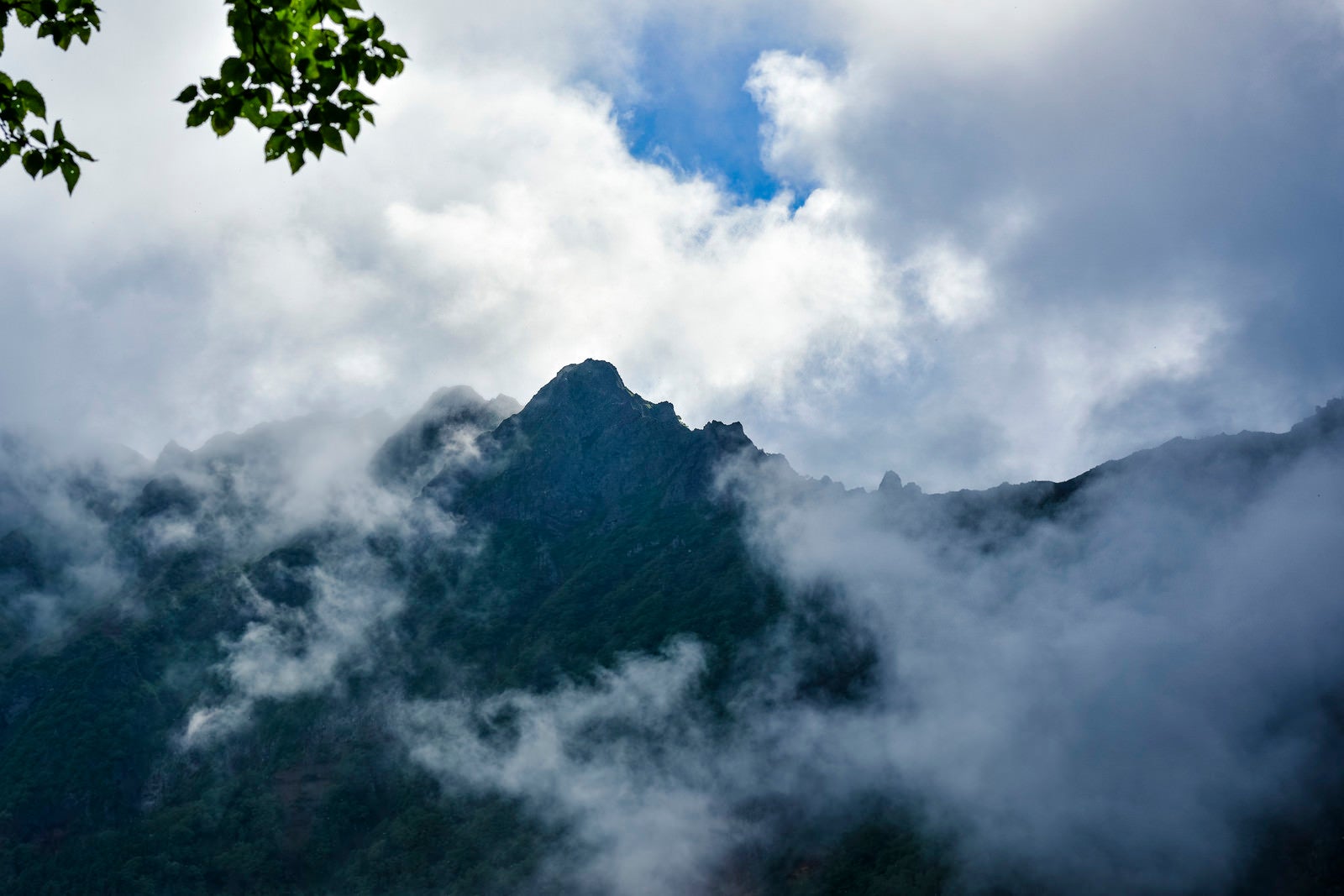 「雲の隙間から顔を見せる八ヶ岳（赤岳）」の写真