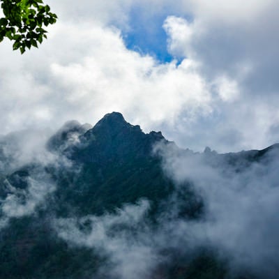 雲の隙間から顔を見せる八ヶ岳（赤岳）の写真