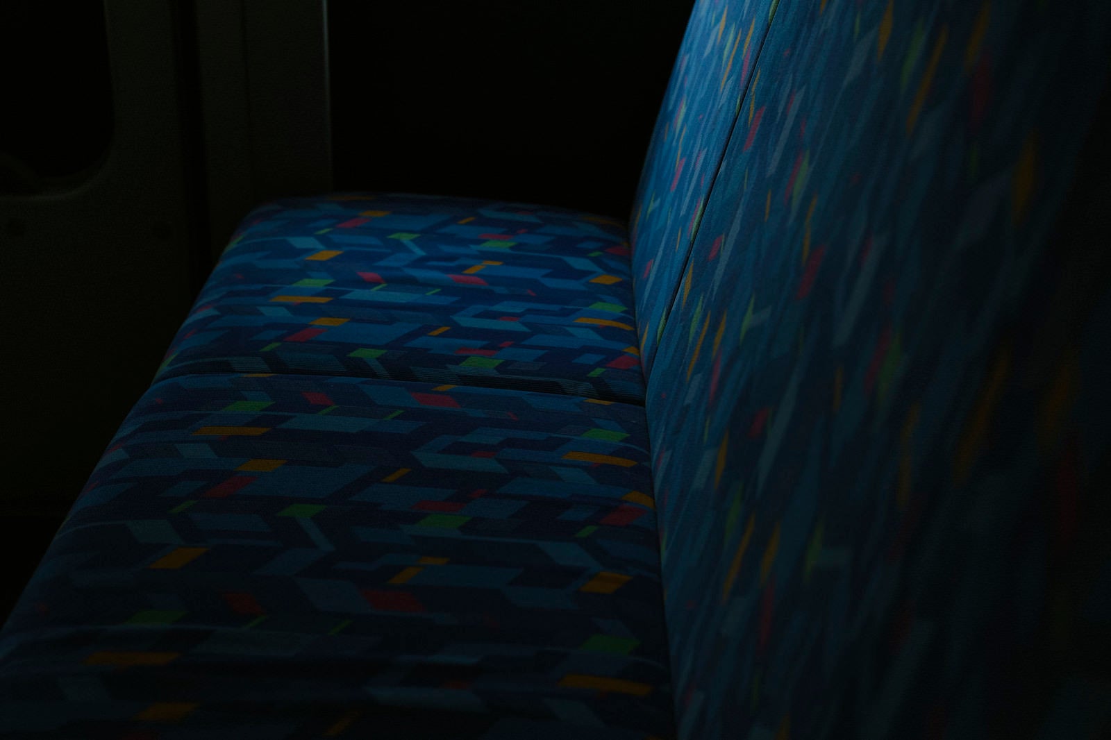 「薄暗い光に照らされるバスの座席」の写真