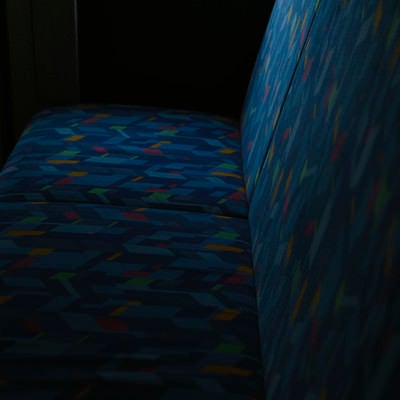 薄暗い光に照らされるバスの座席の写真