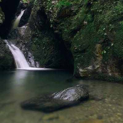 ネジレの滝に浮かぶ岩と静かな水面の写真