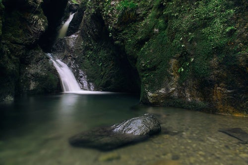 ネジレの滝に浮かぶ岩と静かな水面の写真