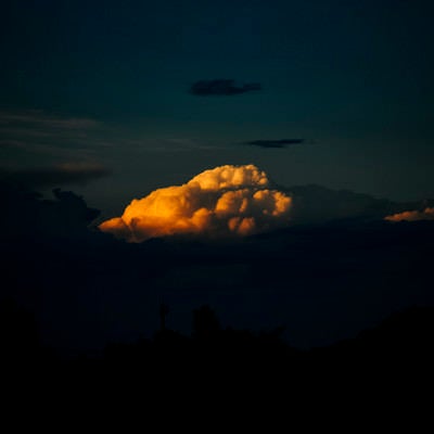 夕日に浮かび上がる丸い雲の表情の写真