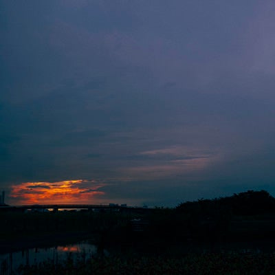 夕日を包み込むように広がる雲の空の写真