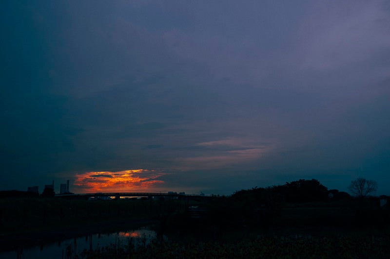 夕日を包み込むように広がる雲の空の写真