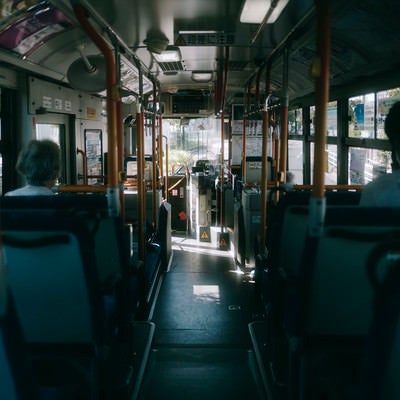 早朝の薄暗い通勤バスの車内の写真
