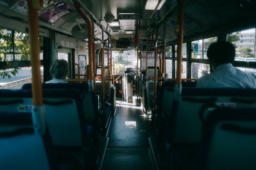 早朝の薄暗い通勤バスの車内の写真