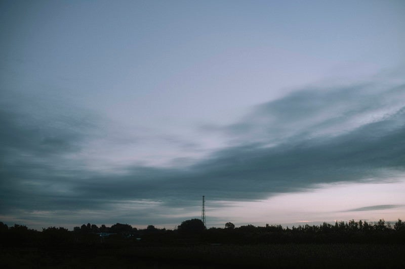 流れゆく雲とゆっくりとやってくる朝の空の写真