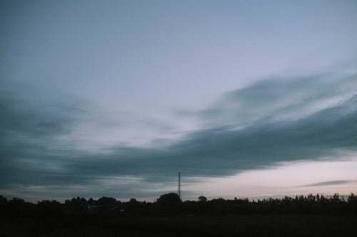 流れゆく雲とゆっくりとやってくる朝の空の写真