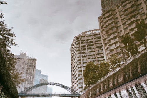 湖面に反射したマンションと橋の写真