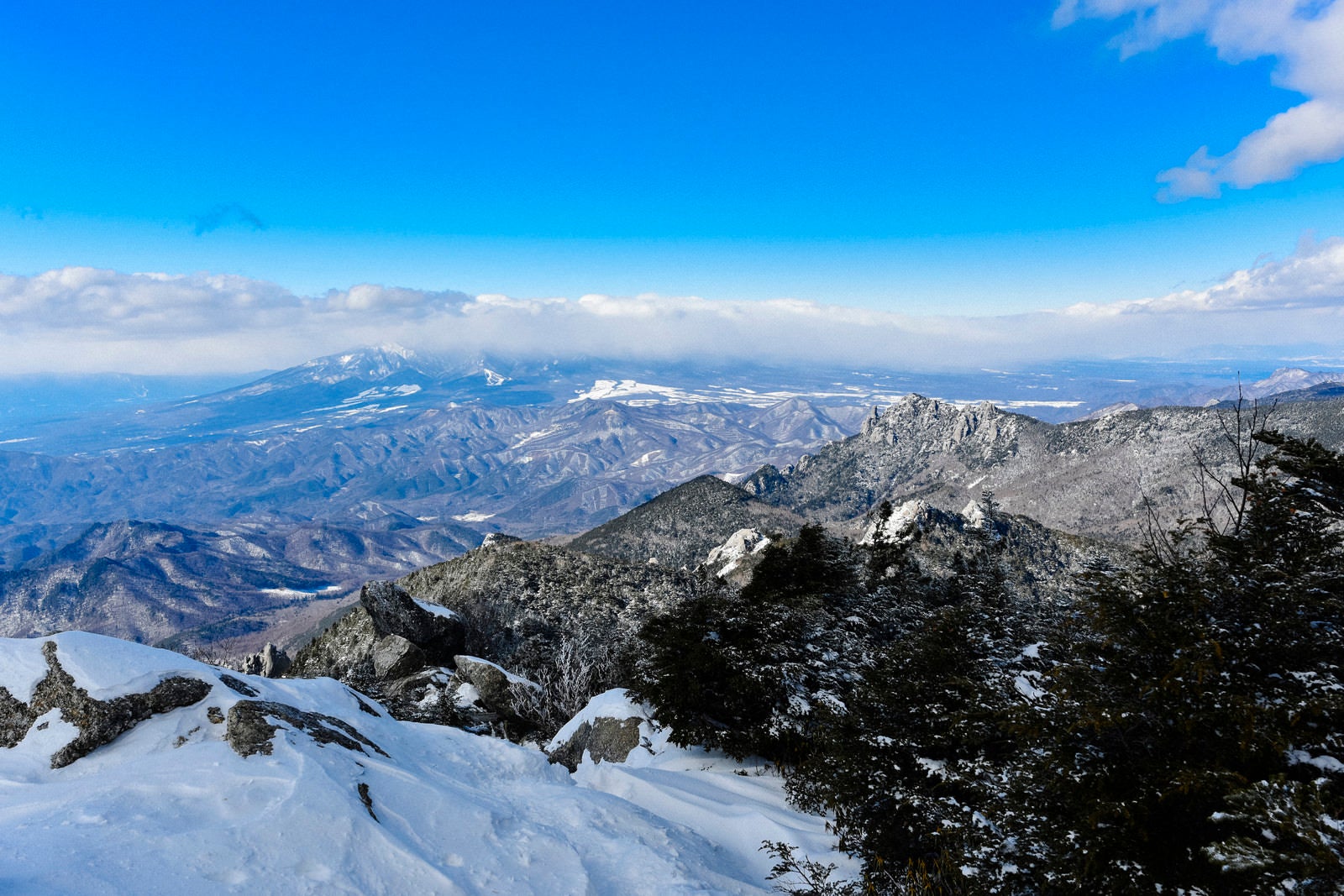 「冬の瑞牆山と雲に覆われた八ヶ岳の遠景（金峰山）」の写真