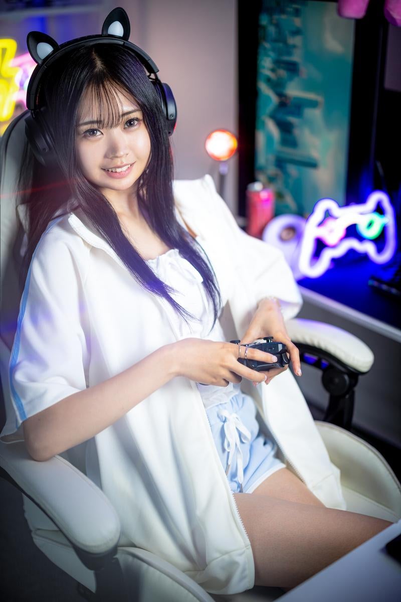 猫耳型のゲーミングヘッドセットを着けてコントローラーでゲームをする女性の写真