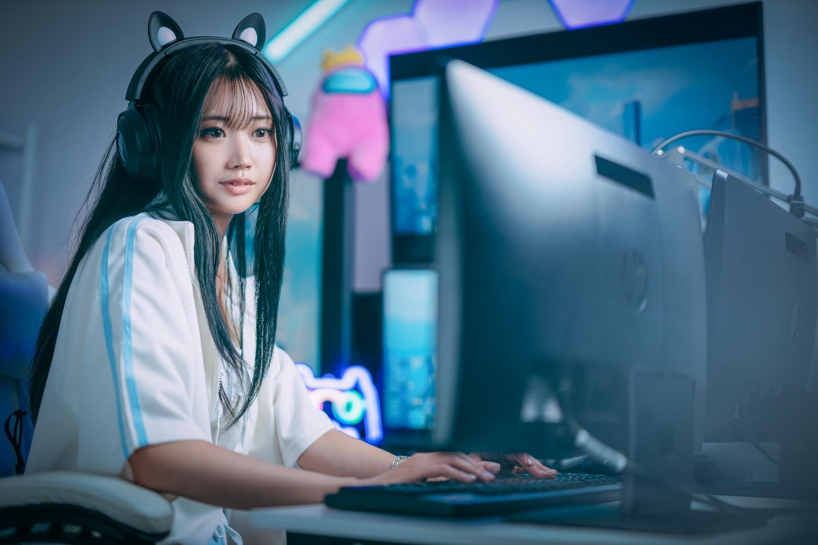 猫耳ヘッドフォンを付けてPC前でゲーム配信する女性ゲーマー［モデル：れいか氏］
